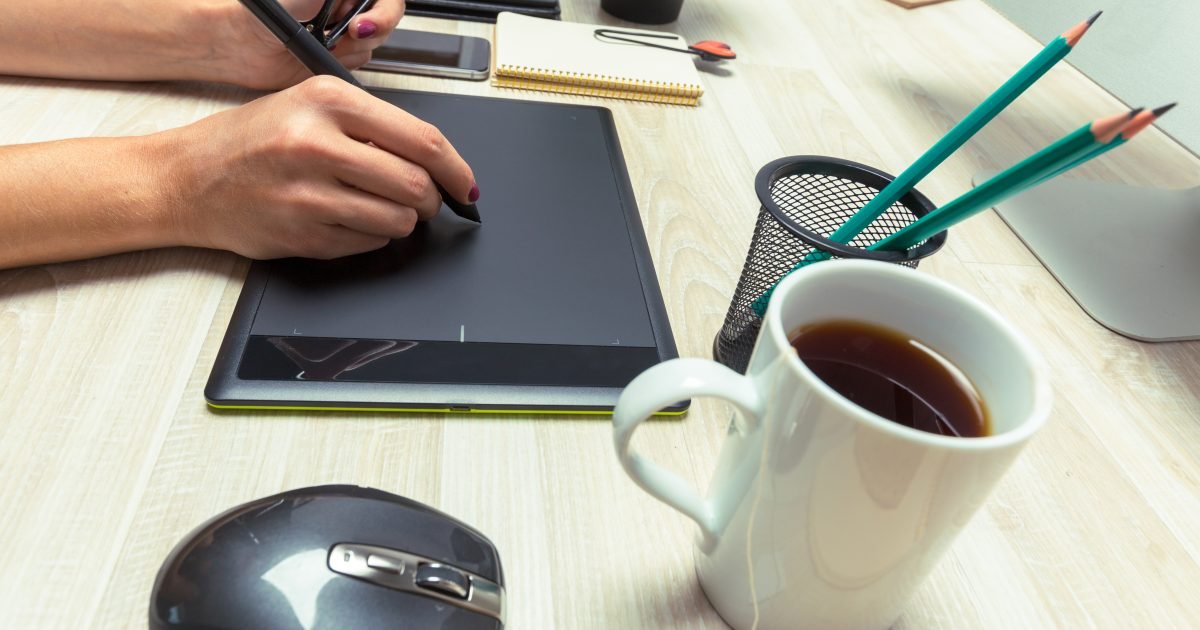 Diseñador trabajando el layout de una página en una tableta gráfica