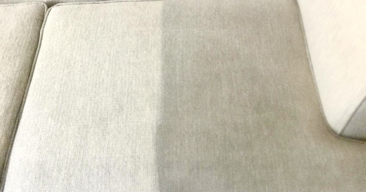 Sofa cushion mid-clean showing the line between soiled and freshly cleaned upholstery